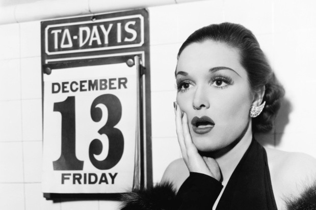 A women with a shocked face next to a calendar with the date of Friday the 13th
