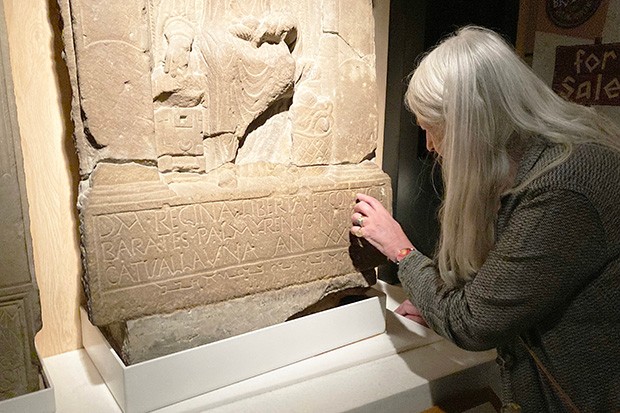 Mary Beard looking at a stone tomb